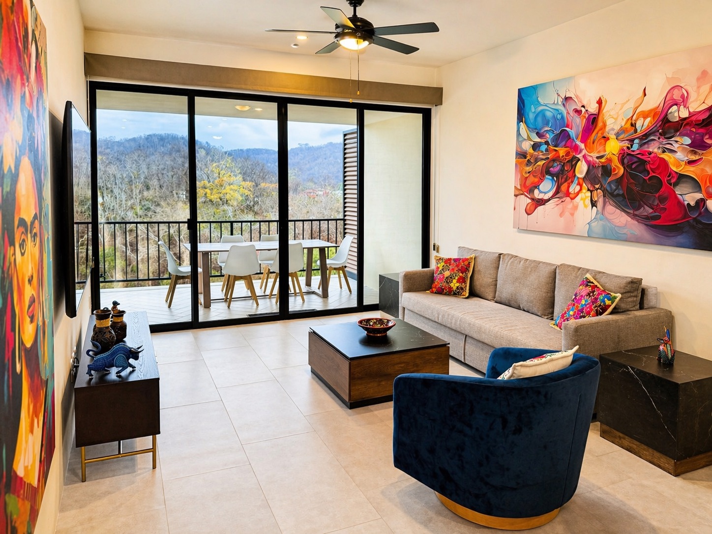 Living area framed by the Frida portrait, splash-art canvas, and balcony dining beyond