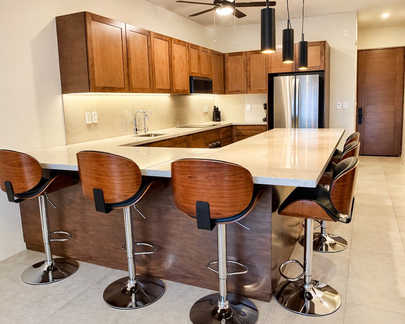 Fully equipped U-shaped kitchen with quartz island, bar seating for 6