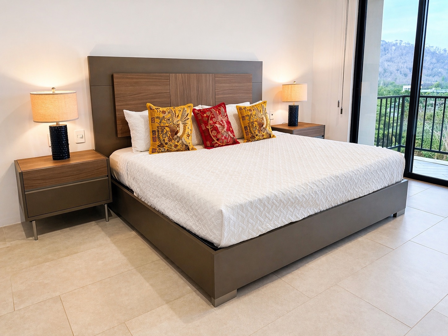 King bed with embroidered pillows and twin nightstand lamps