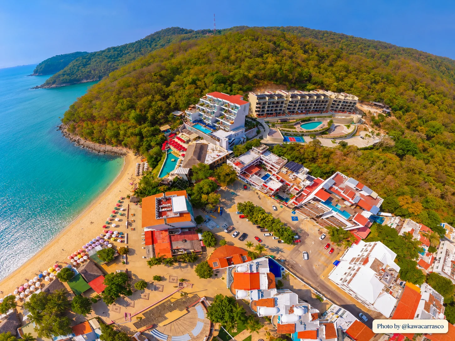 Wide aerial of Playa Santa Cruz with Nirú Las Casitas on the hillside above